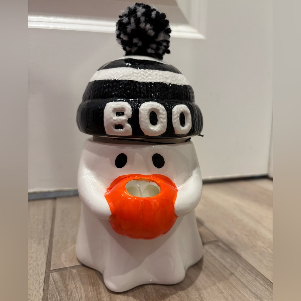 NWT Ghost wearing a striped BOO pompom beanie carrying a pumpkin candle